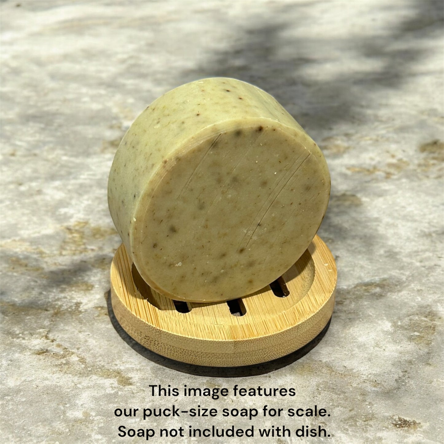 Round soap on top of round soap dish. Marble colored background with text saying the soap is for scale reference and not for sale