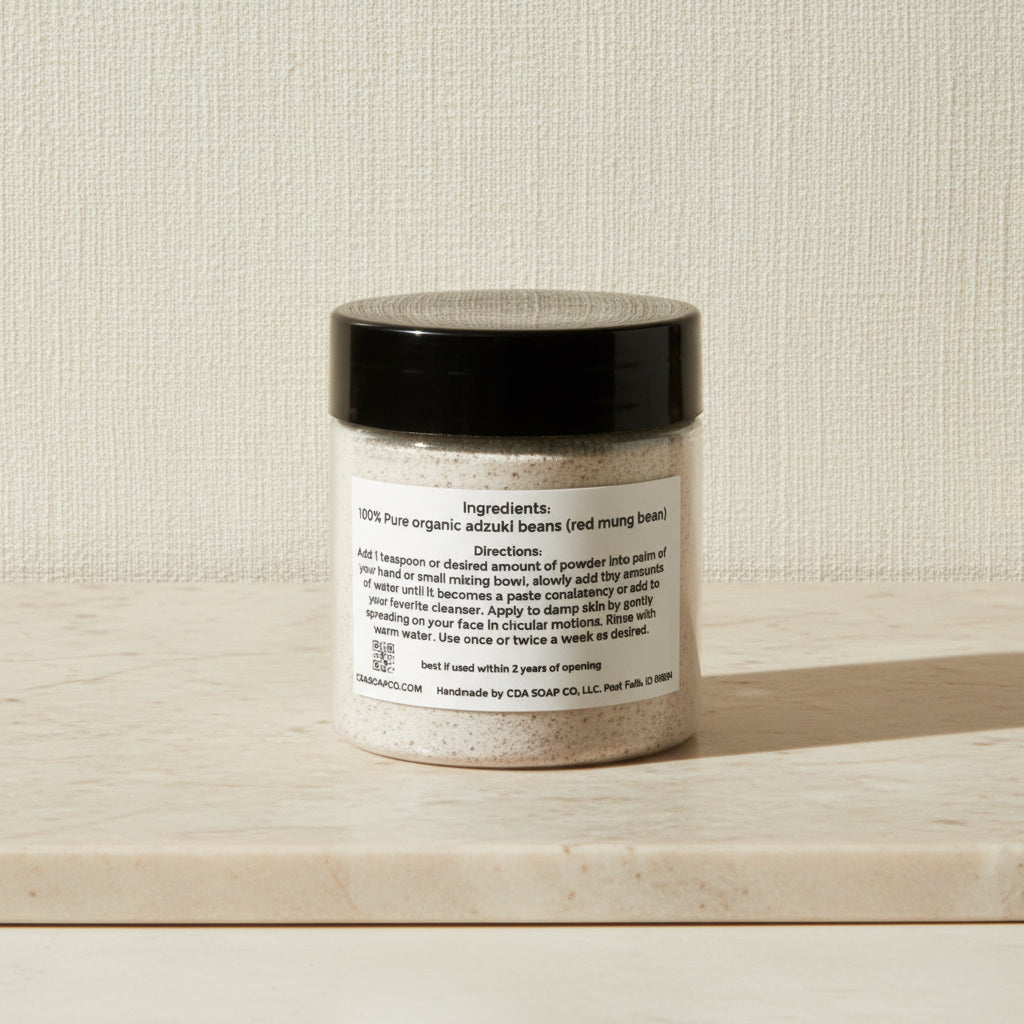 Jar of powder with a black lid on a wooden surface against a beige wall.
