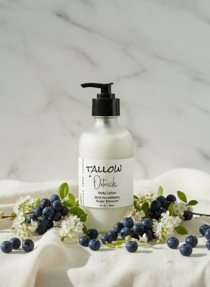 Tallow body lotion bottle with blueberries and white flowers on a light background