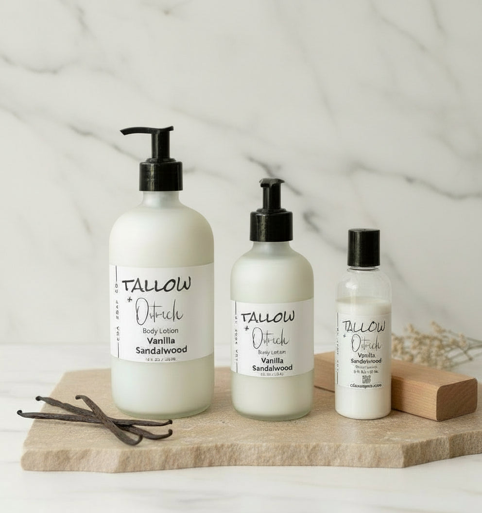 Three bottles of Tallow & Co. body lotion on a wooden board with vanilla beans and sandalwood on a light background.