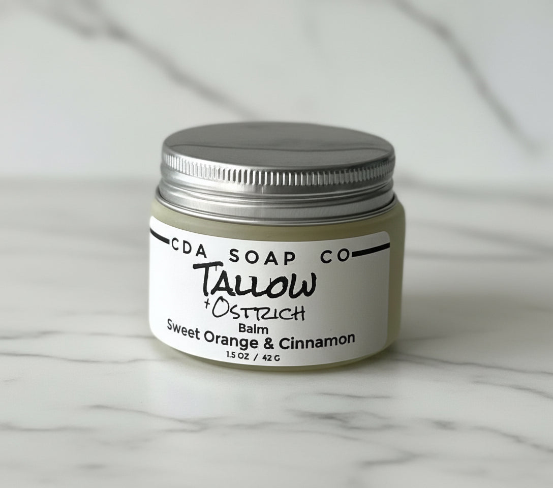 Jar of Tallow + Ostrich balm from CDA Soap Co on a gray background