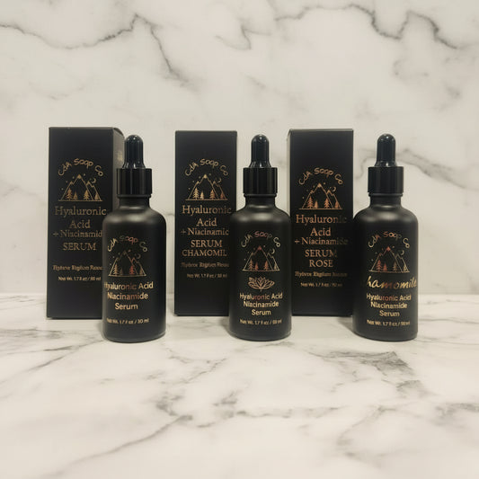 Black serum bottles with droppers and boxes on a marble surface with marble background