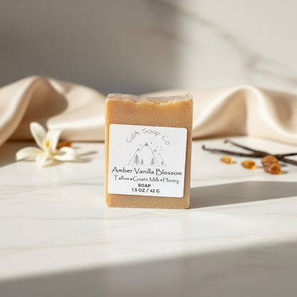 Bar of Amber vanilla blossom soap with a label on a light surface with a neutral background
