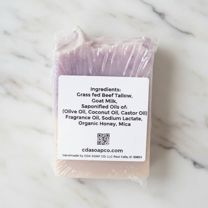 Bar of soap with a label detailing ingredients on a white marble background