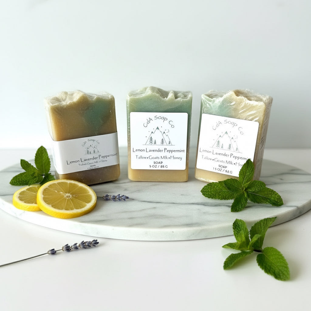 Three soaps on a marble tray with lemon slices and mint leaves on a white background