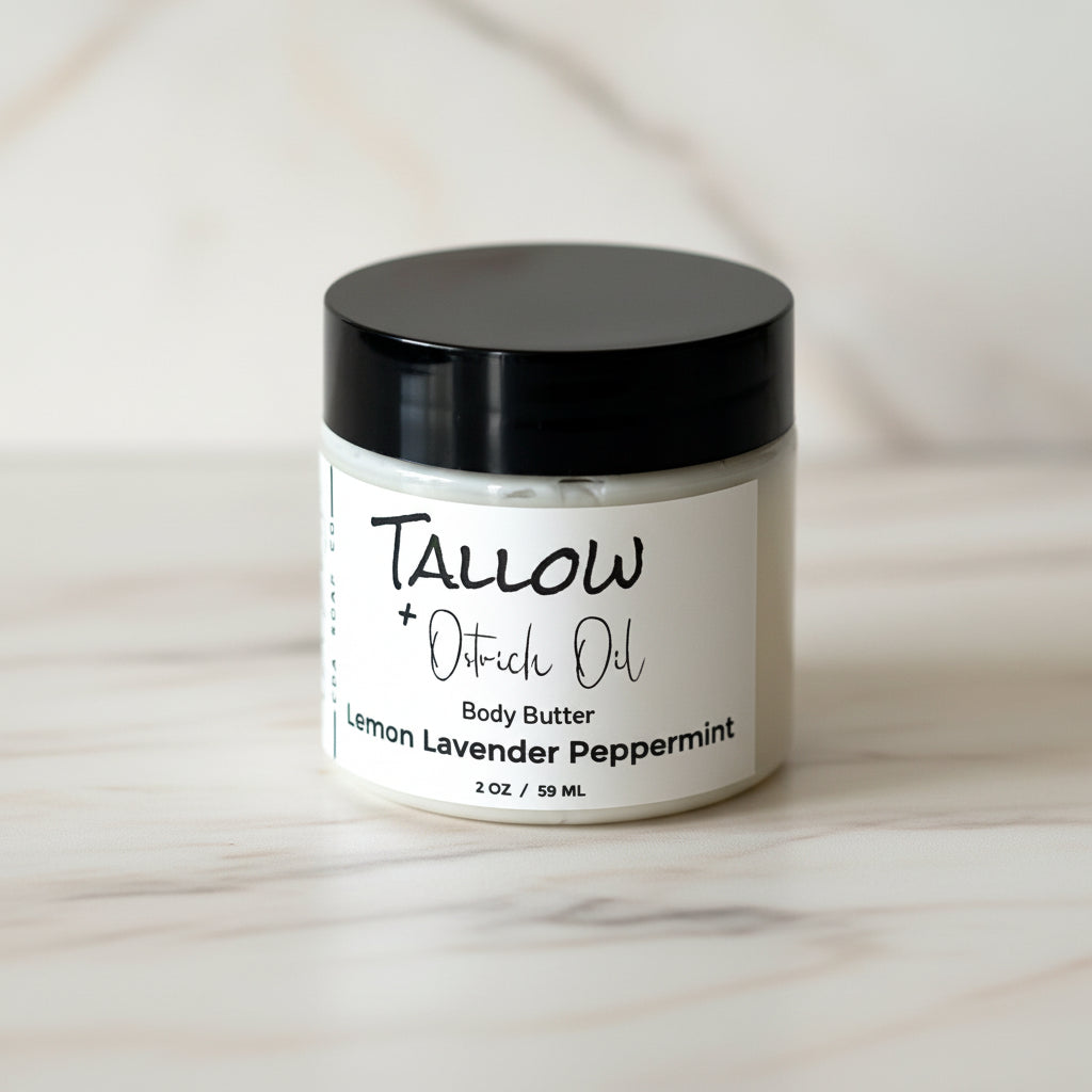 Jar of Tallow + Oatrich Oil body butter with a black lid on a marble surface.