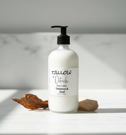 White lotion bottle with black pump on a light gray background with brown tobacco leaves 