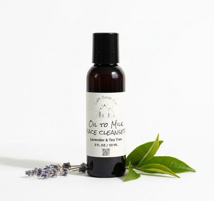 Bottle of Oil to Milk Face Cleanser with lavender and tea tree leaves on a white background