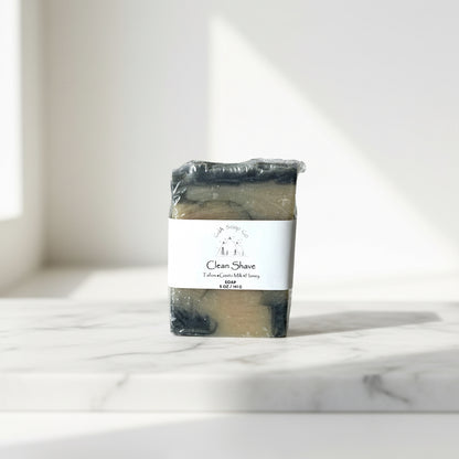 Bar of soap scented “clean shave” with a label on a marble surface