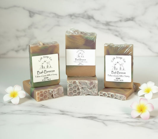 Three bars of Bali Breeze soap with visible branding on a white background with floral decorations.