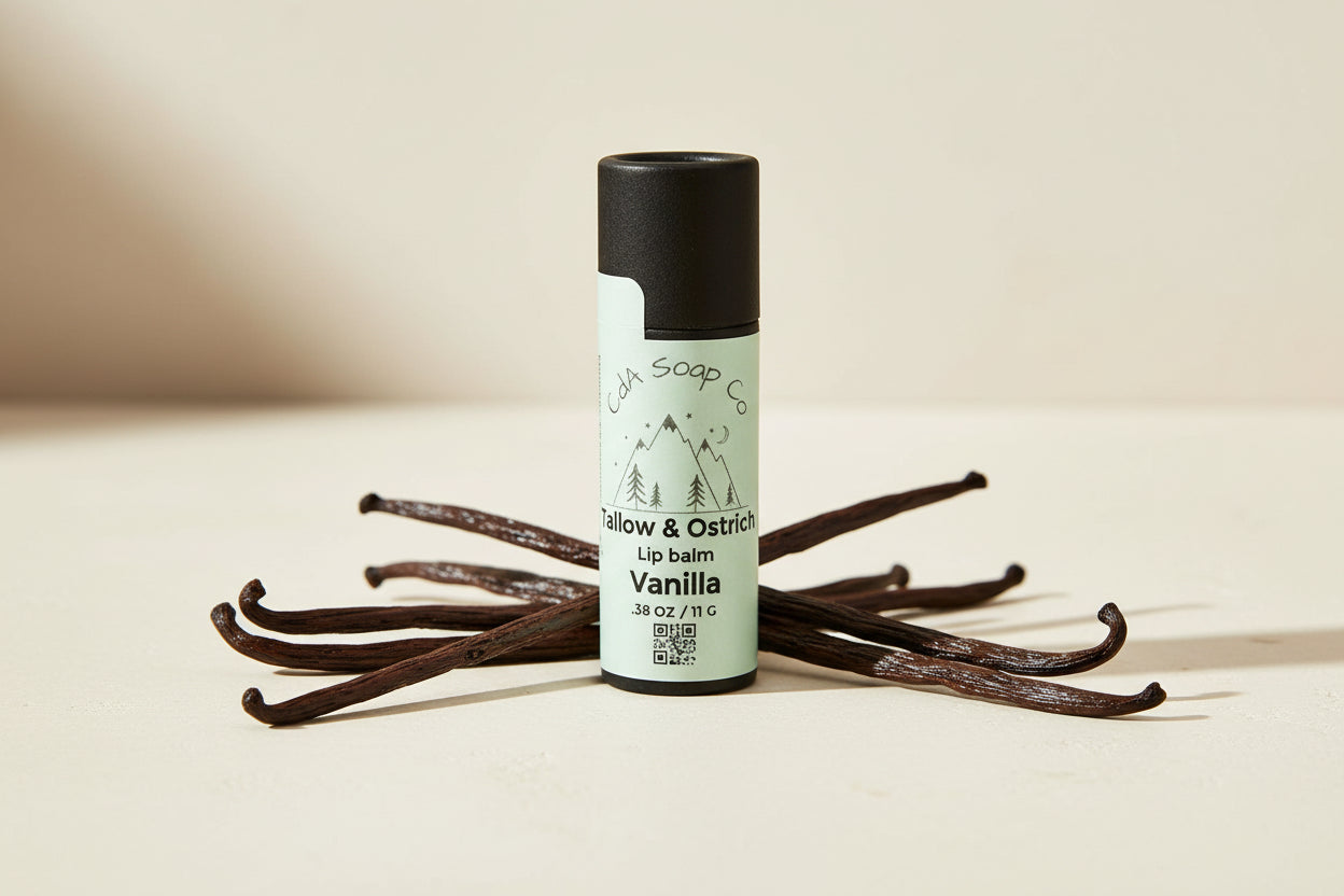 Black Kraft board container Lip balm on a white background. Tallow and ostrich lip balm in vanilla by CdA soap co. 11 g vanilla bean accents in picture 