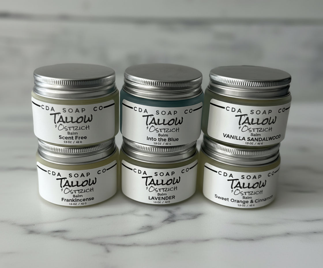 Set of CDA Soap Co. tallow balms on a marble surface