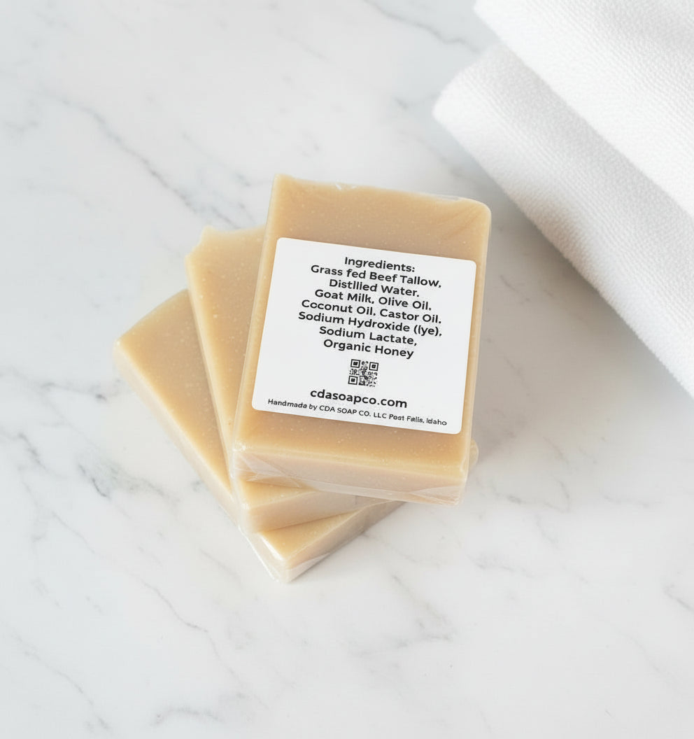 Three bars of soap with a label on a marble surface with a white towel.