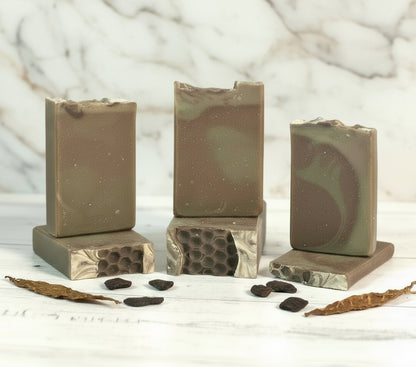 Set of five soap bars with different patterns on a wooden surface