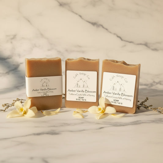 Three bars of Amber Vanilla Blossom soap with packaging on a light background
