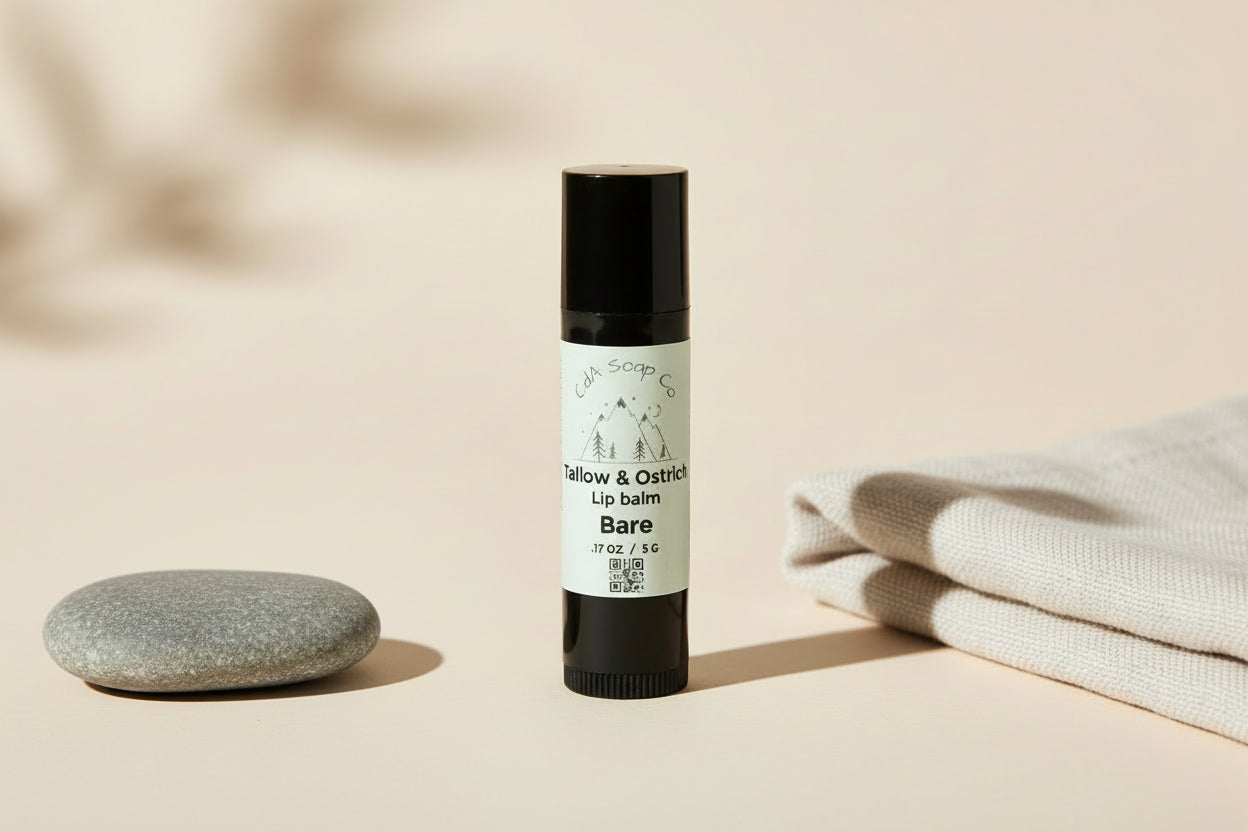 Plastic lip balm container with black caps and white labels featuring Mountain graphics on a white background. Label reads CdA Soap Co. Tallow & Ostrich Lip Balm. Bare. For unscented/ unflavored. Weight 5 g