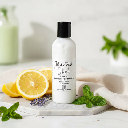 White bottle with black cap labeled 'Tallow Ostrich' on a white surface with lemon slices and mint leaves.