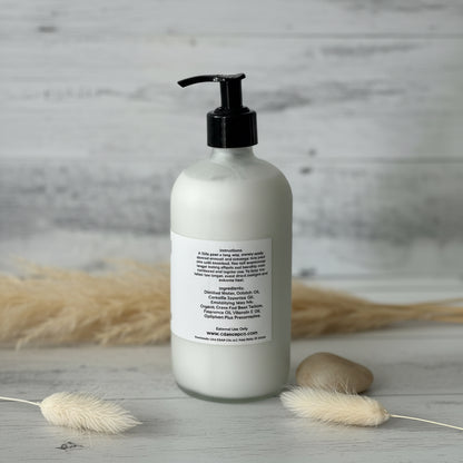 White bottle with black pump on a wooden surface with dried plants