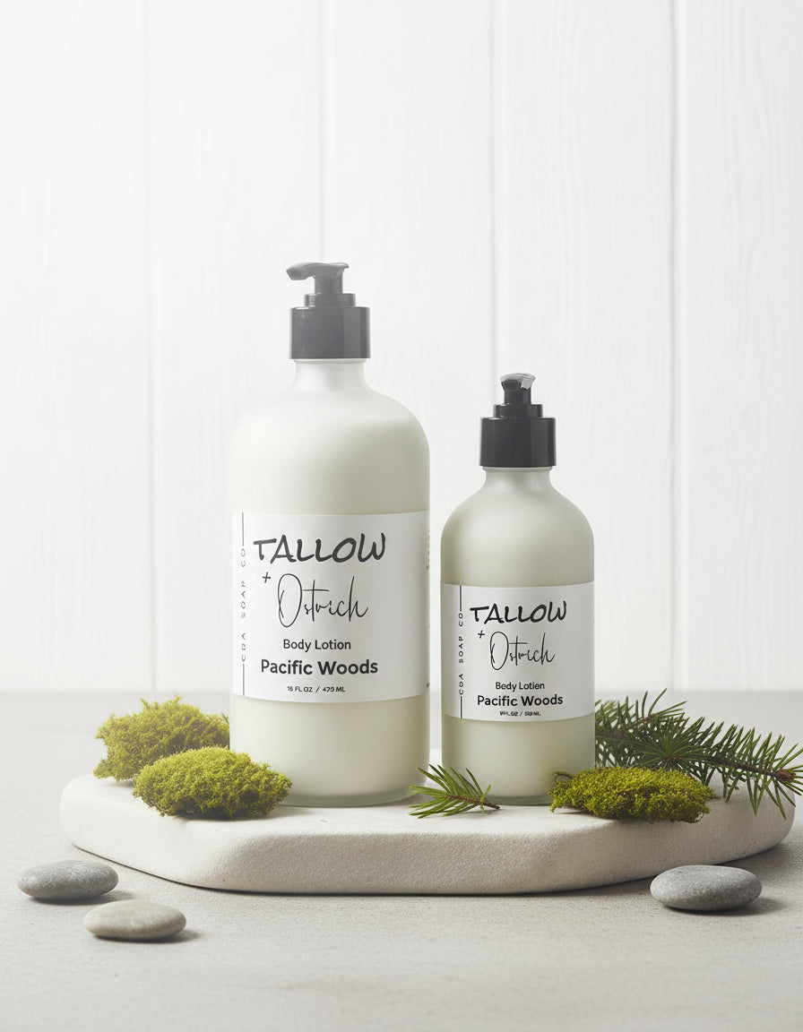 Two bottles of Tallow & Pstrich CdA soap Co. body lotion on a white surface with greenery.