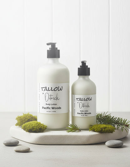 Two bottles of Tallow & Pstrich CdA soap Co. body lotion on a white surface with greenery.