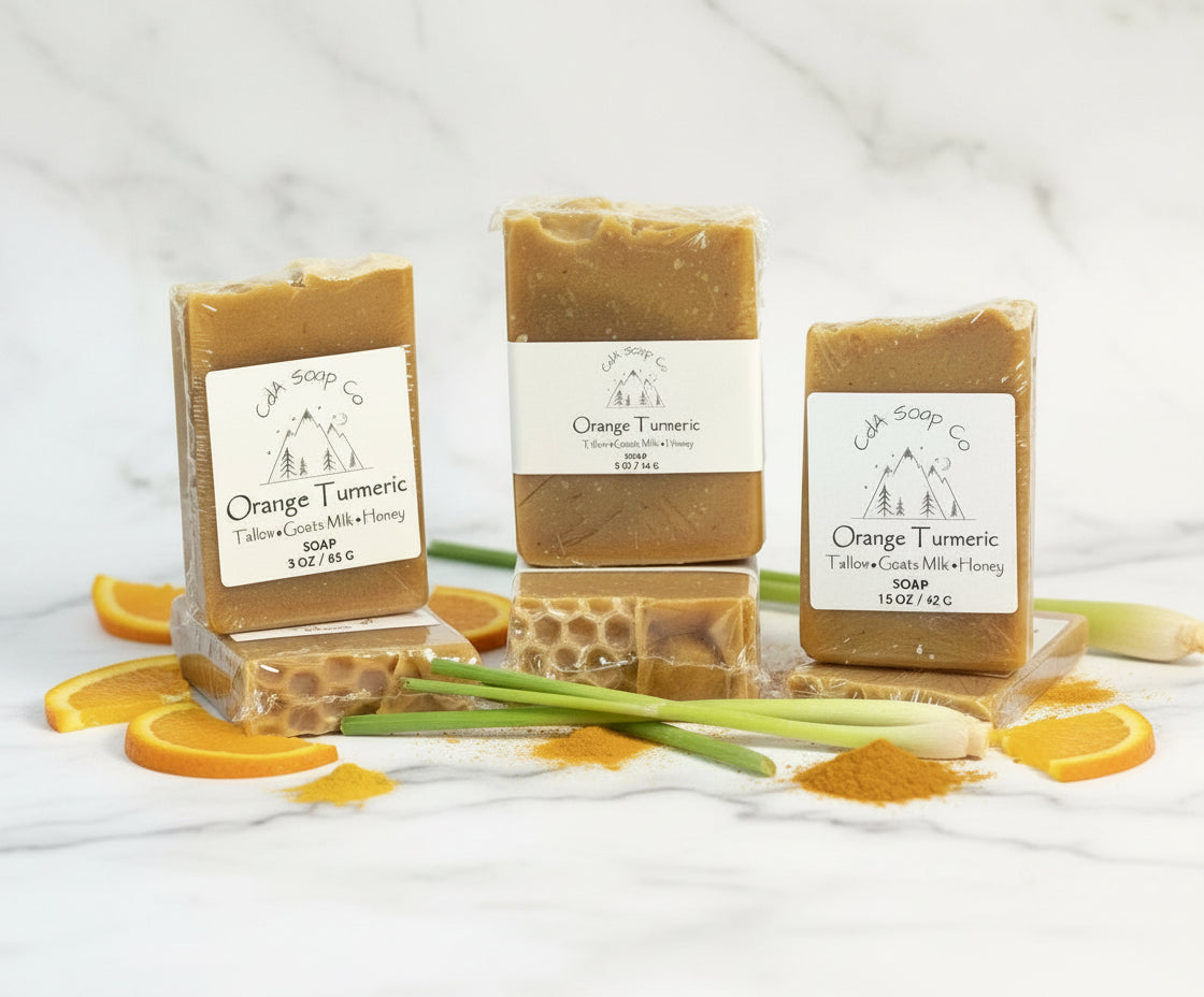 Three bars of Orange Turmeric soap with visible labels on a white background.