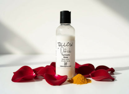 Body lotion bottle with turmeric root and pink petals on a white background