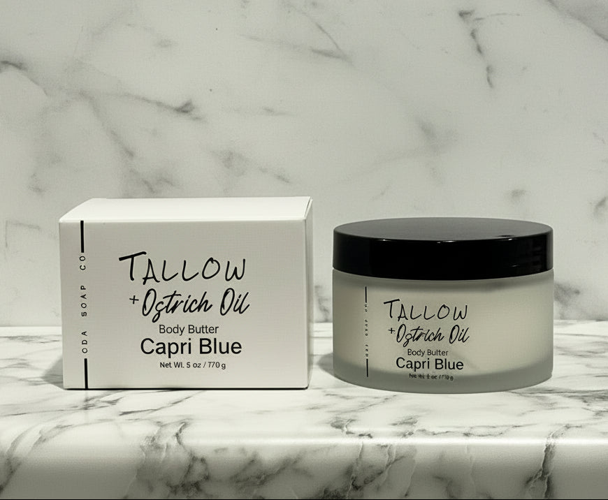 Capri Blue Tallow + Ostrich Oil body butter jar and box on a marble surface with wooden background