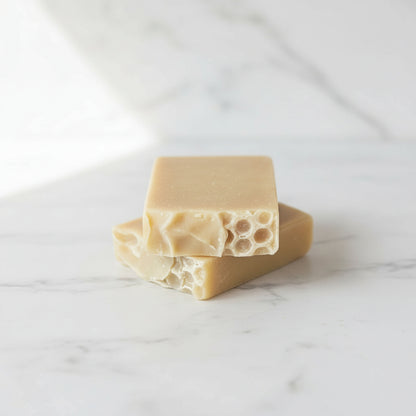 Three bars of natural soap with honeycomb texture on a light surface