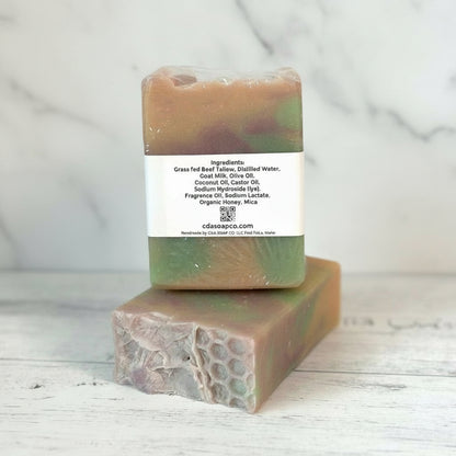 Two bars of soap with a label on a wooden surface