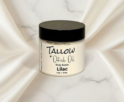 A frosted white glass jar with a black lid labeled 'Tallow Ostrich Oil Body Butter Lilac'.