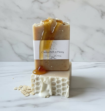 Bar of soap with honey drizzle and oats on a white marble background