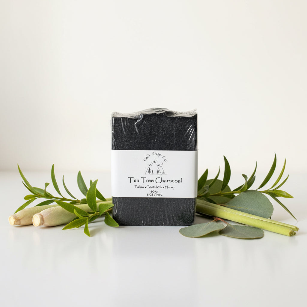 Tea Tree Charcoal soap bar with eucalyptus leaves on a white background