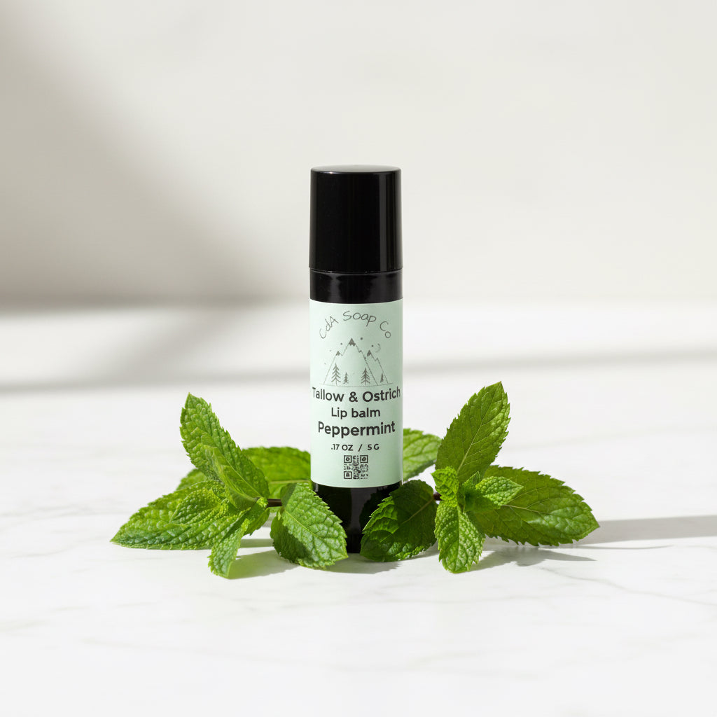 Black lip balm tube with white label. Peppermint leaf accents. White background 