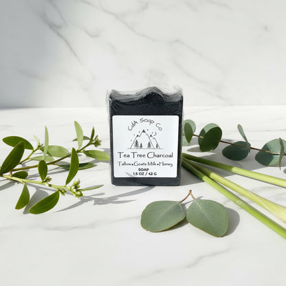 Tea Tree Charcoal soap bar in packaging on a wooden surface