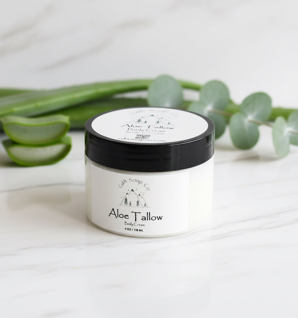 Jar of aloe tallow body cream with aloe vera leaves in the background