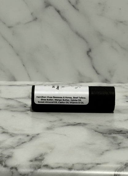 kraft board tube of lip balm with a label on a marble surface
