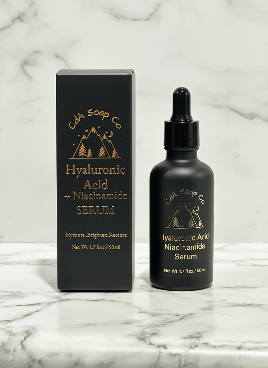 Black serum bottle with dropper and packaging on a light wooden surface