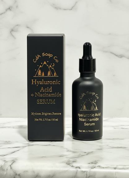 Black serum bottle with dropper and packaging on a light wooden surface