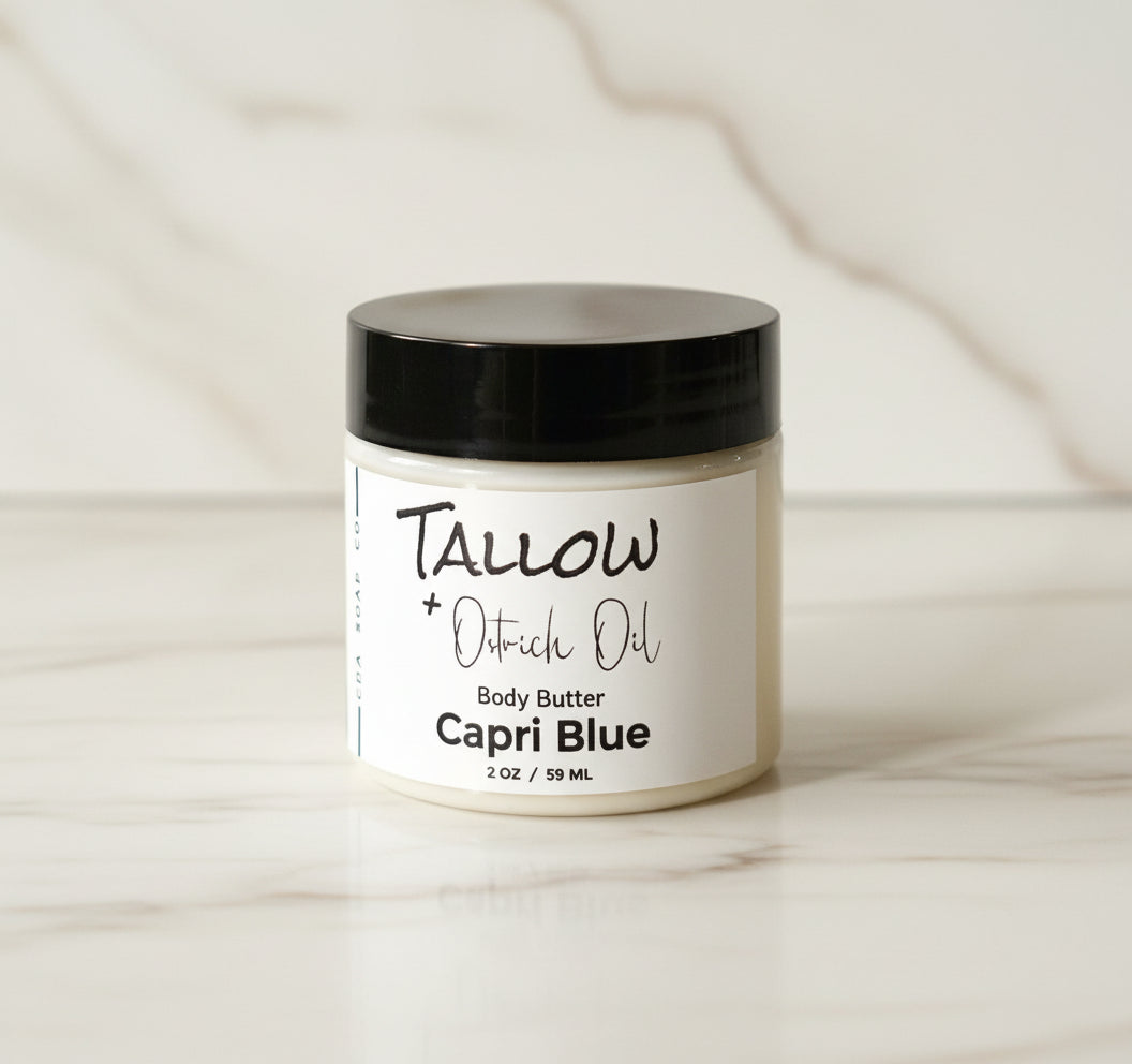 a jar of capri blue tallow body butter white marble background