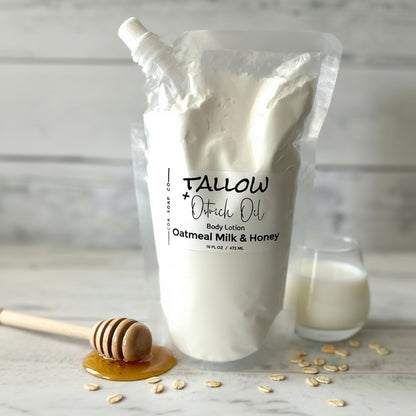 Body lotion bag labeled 'Tallow' with a glass of milk and honey dipper on a marble surface.