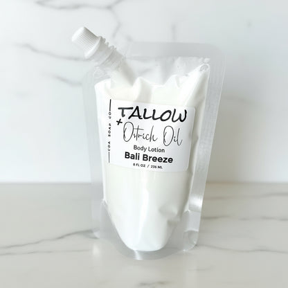 Body lotion pouch labeled 'Tallow + Ostrich Oil Bali Breeze' on amarble surface.
