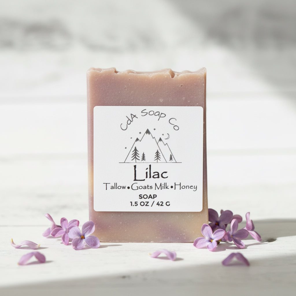 Bar of lilac soap with a CDA Soap Co label on a white background with lilac flowers.