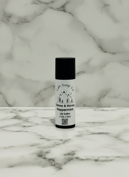 kraft board tube of lip balm on a textured surface with a marble pattern