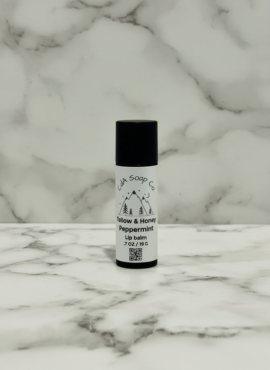 kraft board tube of lip balm on a textured surface with a marble pattern