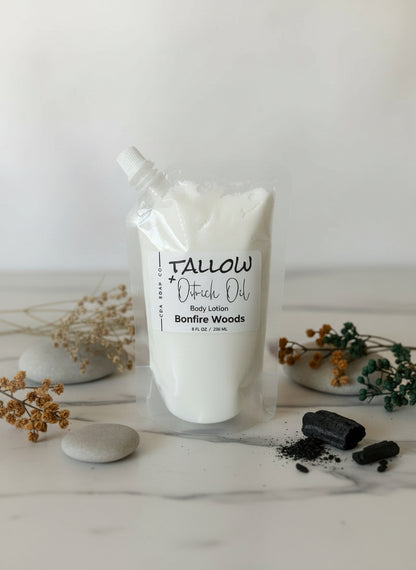Tallow body lotion in plastic pouch packaging on a white surface with decorative elements