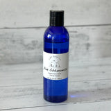 Blue bottle of Aloe Chamomile facial toner on a wooden surface