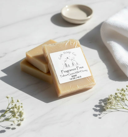 Two bars of soap with a 'Fragrance Free' label on a light surface with flowers.