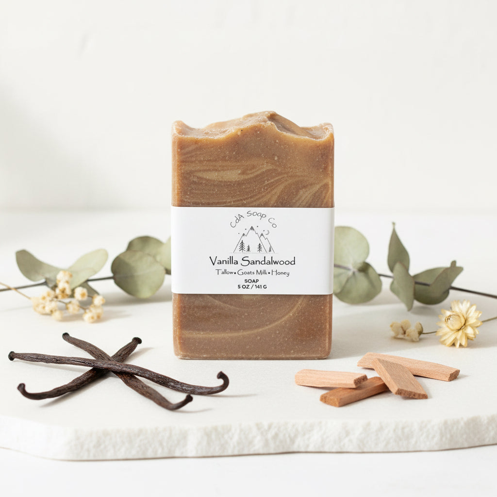 Vanilla sandalwood soap bar with vanilla beans and eucalyptus leaves on a white background
