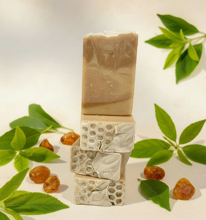 Stack of natural soap bars with green leaves and berries on a light background