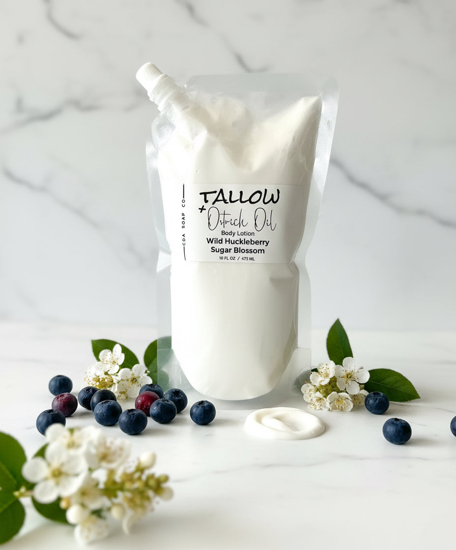 Bag of Tallow + Oatrich Oil body lotion with huckleberries and flowers on a white background